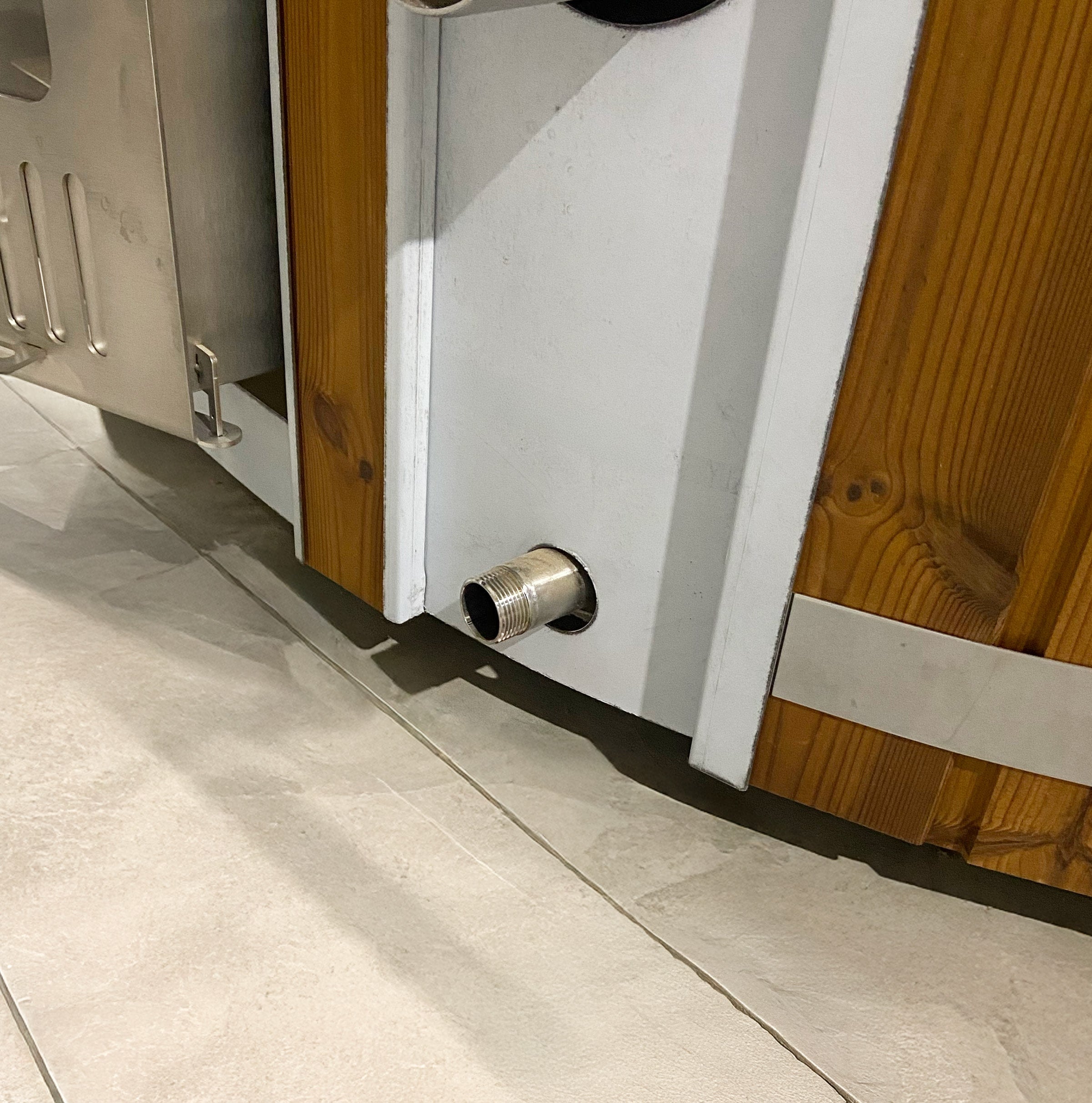 Hot tub water drain outlet with stainless steel connection at the base of the tub.