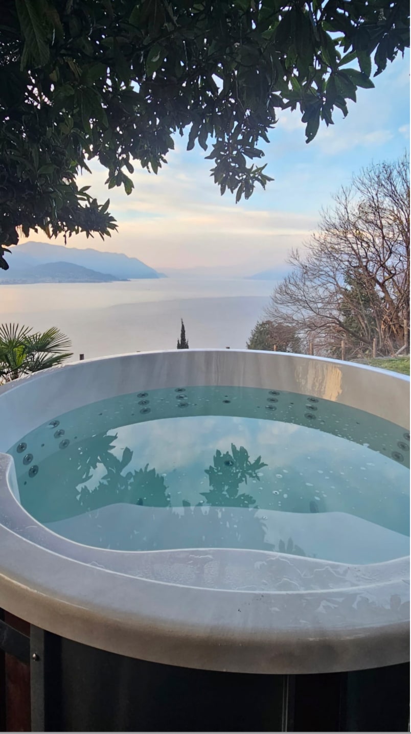 Round Gardenvity hot tub with lake view in Italy – minimalist outdoor setup.