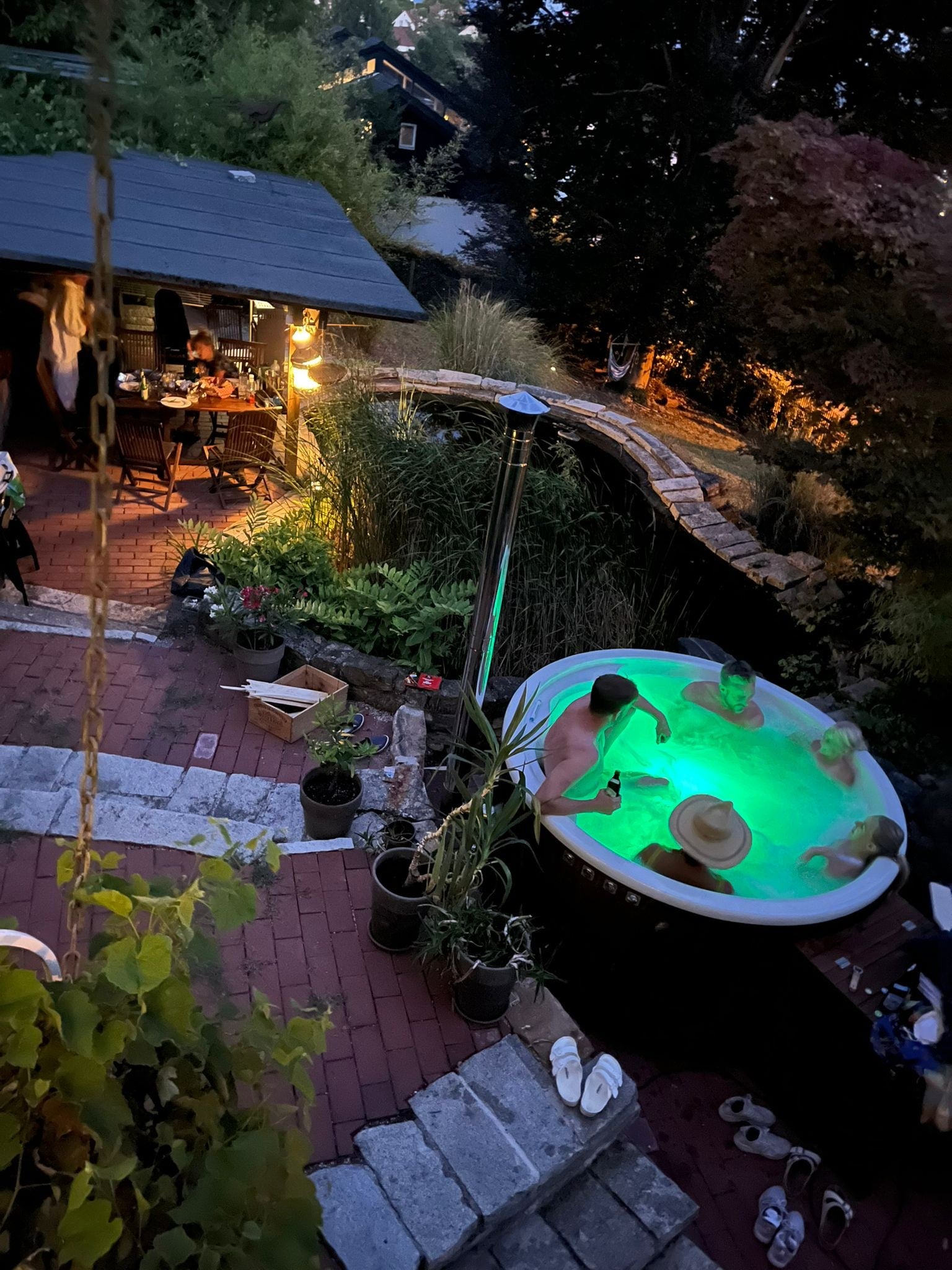 Steam rising from Gardenvity wood fired hot tub with fire burning inside stainless steel stove.