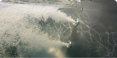 Hydro massage jets creating water movement inside a wood-fired hot tub