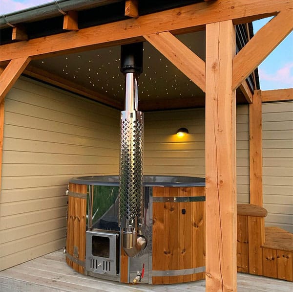 A woof-fired hot tub shown safely installed on a terrace gazebo.