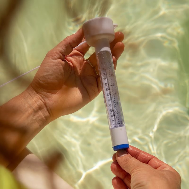 Inspecting the water temperature with a floating thermometer.