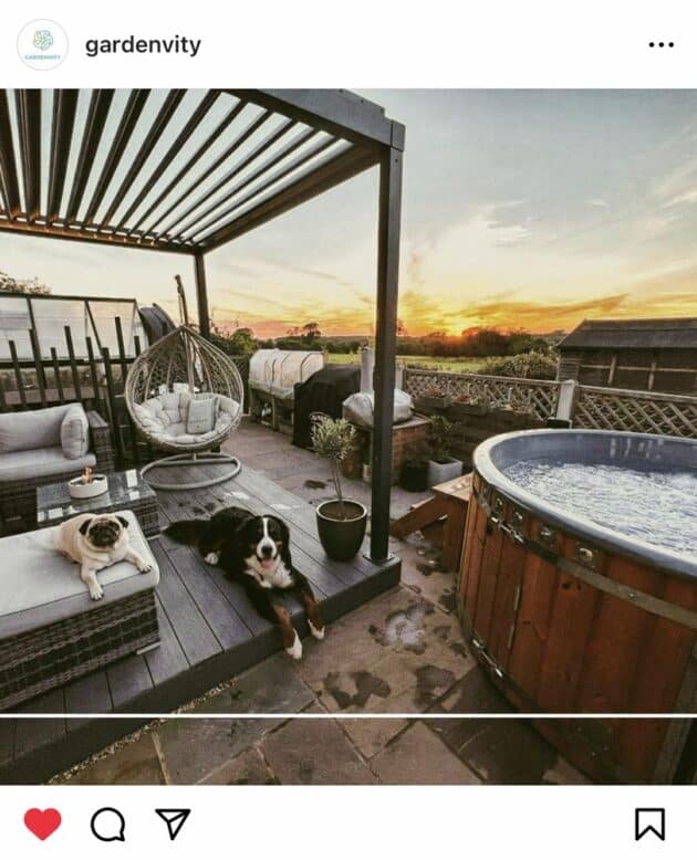 A Gardenvity wood-fired hot tub next to a private pergola in a cosy backyard