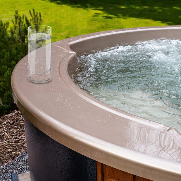 A glass of water is placed on the wood-fired hot tub's minibar