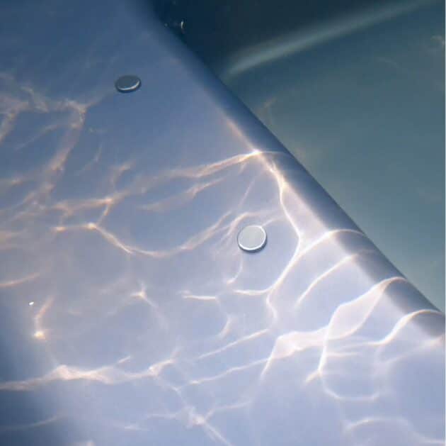 Air jets of the wood-fired hot tub when turned off underwater, nice sun flares on fragments of the liner
