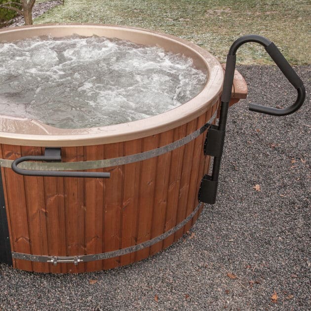 Wood-fired hot tub with black handrail accessory