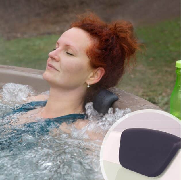 A woman relaxing in a wood-fired hot tub, leaning on a cushioned headrest